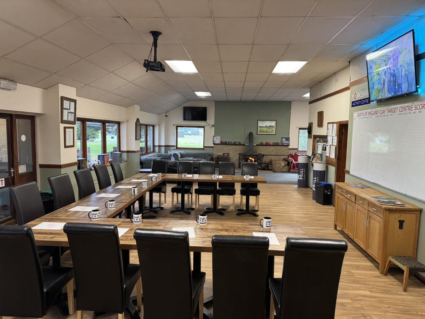 Clubhouse meeting room at Yorkshire Activity Centre set up for a corporate meeting with U-shaped tables, projector and screen
